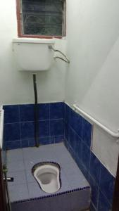 a blue tiled bathroom with a toilet with a window at Homestay Bonda Azizah 11-13pax in Kota