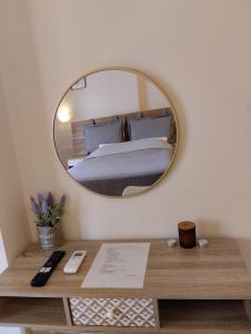 una camera da letto con un letto e uno specchio a parete di New cozy sd No1 in Tzafi Apartments a Mesongi