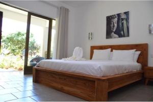 a bedroom with a large bed with white sheets at Garden lodge in Pereybere