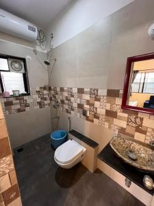 a bathroom with a toilet and a sink at Gokul Garden in Pune