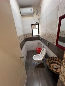 a small bathroom with a toilet and a window at Gokul Garden in Pune