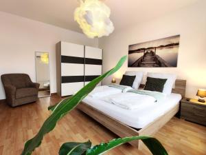 um quarto com uma cama e um vaso de plantas em Stilvolles Apartment in Leipzig zwischen Flughafen, Messe, Porsche und BMW em Leipzig