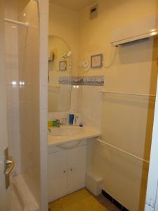 ein weißes Bad mit einem Waschbecken und einer Dusche in der Unterkunft Espadon in Neufchâtel-Hardelot