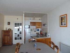 讷沙泰勒阿尔代洛Espadon的一间带桌子的厨房和一间带冰箱的厨房