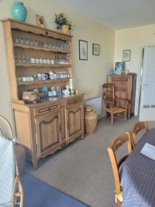 a room with a wooden cabinet with dishes on it at Espadon in Neufchâtel-Hardelot