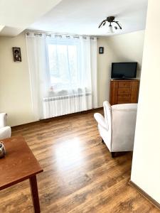een woonkamer met een bank en een tv bij Domek u podnóża Skrzycznego in Lipowa