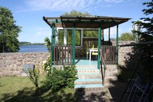 gazebo con tavolo e scale accanto all'acqua di Ferienwohnung mit großem Garten und Blick zum See a Fürstenwerder