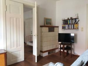 Camera dotata di soggiorno con TV e porta. di Ferienwohnung mit großem Garten und Blick zum See a Fürstenwerder