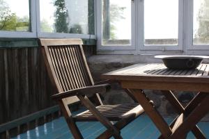 una sedia in legno seduta accanto a un tavolo di legno di Ferienwohnung mit großem Garten und Blick zum See a Fürstenwerder