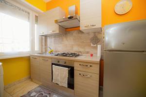 a kitchen with a stove and a refrigerator at Appartamento La Coccinella in Lido di Ostia