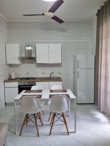 kuchnia ze stołem, krzesłami i lodówką w obiekcie Romano Appartamenti w Trapani