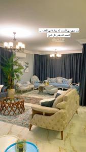 a living room with couches and tables in it at شقة اطلالة النيل in Cairo