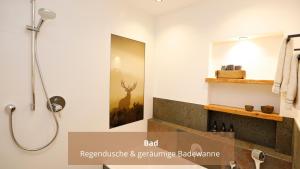 a bathroom with a shower with a picture of a deer on the wall at Chalet WaldHäusl luxuriöse Ferienwohnungen mit Sauna & Whirlpool, Kamin, Balkon oder Terrasse mit Bergblick in Heiligenblut