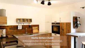 a kitchen with white cabinets and a counter top at Chalet WaldHäusl luxuriöse Ferienwohnungen mit Sauna & Whirlpool, Kamin, Balkon oder Terrasse mit Bergblick in Heiligenblut
