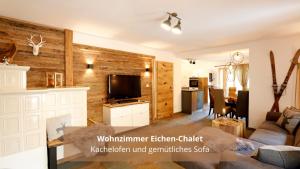 a living room with a couch and a tv at Chalet WaldHäusl luxuriöse Ferienwohnungen mit Sauna & Whirlpool, Kamin, Balkon oder Terrasse mit Bergblick in Heiligenblut