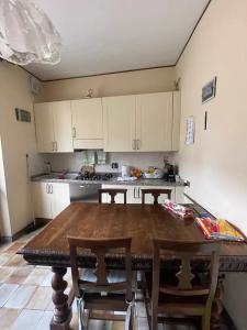 eine Küche mit einem Holztisch und weißen Schränken in der Unterkunft Giuditta B&B in Ciriè