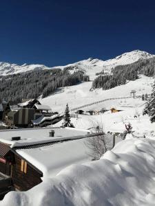 uma aldeia coberta de neve com uma montanha ao fundo em Superbe studio aux 7 Laux em La Ferrière
