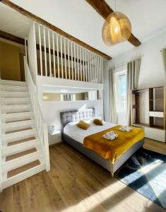 Un dormitorio con una cama blanca y una escalera en Les 3 anges de Sigean, en Sigean