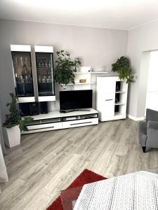 ein Wohnzimmer mit weißen Möbeln und einem Flachbild-TV in der Unterkunft Domek u podnóża Skrzycznego in Lipowa