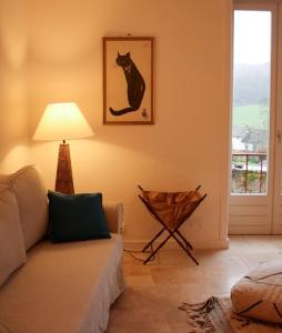 sala de estar con sofá y una foto de gato en la pared en Pannonica charmante maison champêtre, en Montagny-sur-Grosne