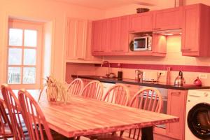 a kitchen with a table and chairs and a microwave at Pannonica charmante maison champêtre in Montagny-sur-Grosne