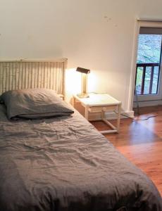 1 dormitorio con 1 cama y 1 mesa con lámpara en Pannonica charmante maison champêtre, en Montagny-sur-Grosne