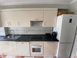 a kitchen with white appliances and a white refrigerator at Apartamento SILDA in Torre del Mar