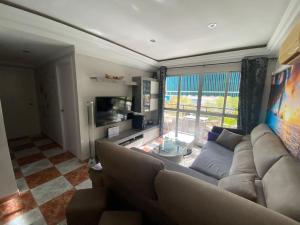 a living room with a couch and a tv at Apartamento SILDA in Torre del Mar