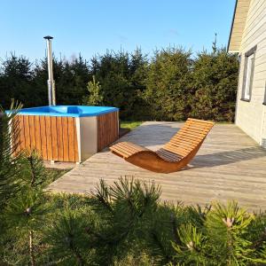 a deck with a chair and a swimming pool at Ciche Wydmy in Sasino