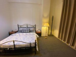 um quarto com uma cama e um candeeiro em The 1st Night Hotel em Amã