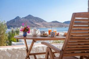 a wooden table with food and drinks on a patio at Theologos Houses in Grikos