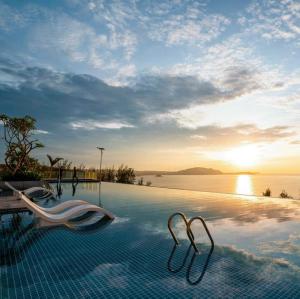 a swimming pool with a view of the ocean at Apec Mandala Cham Bay Mũi Né S2411 in Ấp Long Sơn