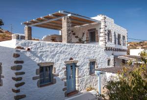 a white building with a blue door on it at Theologos Houses in Grikos