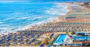 an aerial view of a beach with umbrellas and the ocean at Pisa Happy House in Pisa