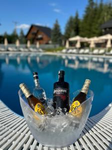 a bowl filled with bottles of alcohol next to a swimming pool at Domeniul CRIS Vatra Dornei in Vatra Dornei +47 photos