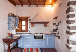 a small kitchen with blue cabinets and a sink at Theologos Houses in Grikos