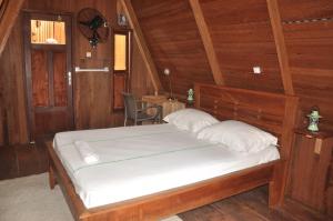 1 dormitorio con 1 cama en una cabaña de madera en KSW BASE NAUTIQUE Isonalambo, en Kribi