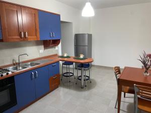 a kitchen with blue cabinets and a table with chairs at CASA MAJA casa per vacanze abruzzo in Lettomanoppello