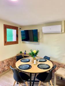 a dining room with a table with chairs and a television at Villa a pie de playa in Moaña