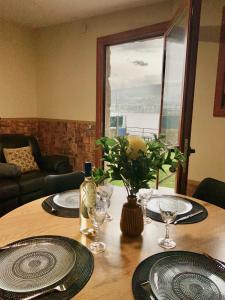 stół jadalny z talerzami i okularami oraz okno w obiekcie Villa a pie de playa w mieście Moaña