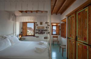 a bedroom with a white bed and a window at Theologos Houses in Grikos