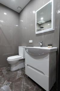 uma casa de banho com um lavatório branco e um WC. em Apartment 45 em Tbilisi