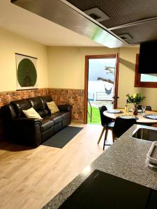 a living room with a leather couch and a table at Villa a pie de playa in Moaña +25 photos