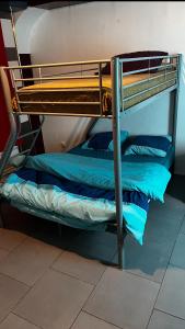a bunk bed in a room with blue sheets at la chambre de Jade in Hirson