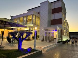 a building with a tree in front of it at Hotel Colis in Tirana