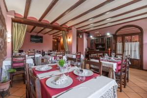 a restaurant with tables and chairs with red tablecloths at Hotel - Restaurante Prado Del Navazo in Albarracín