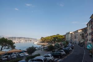 a row of cars parked on a street next to a river at Fezzano / Portovenere Stilish double rooms with sea view, balcony or small courtyard in Fezzano