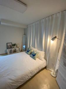 1 dormitorio con 1 cama blanca y 1 lámpara en Time House - Dongdaemun district, en Seúl