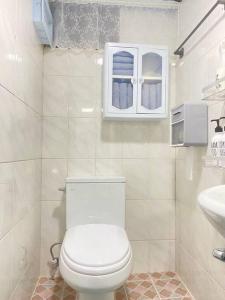 a white bathroom with a toilet and a sink at Time House - Dongdaemun district in Seoul
