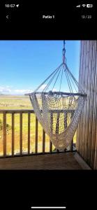 a hammock hanging from a porch with a fence at Beautiful cottage with Mountain View in Fludir